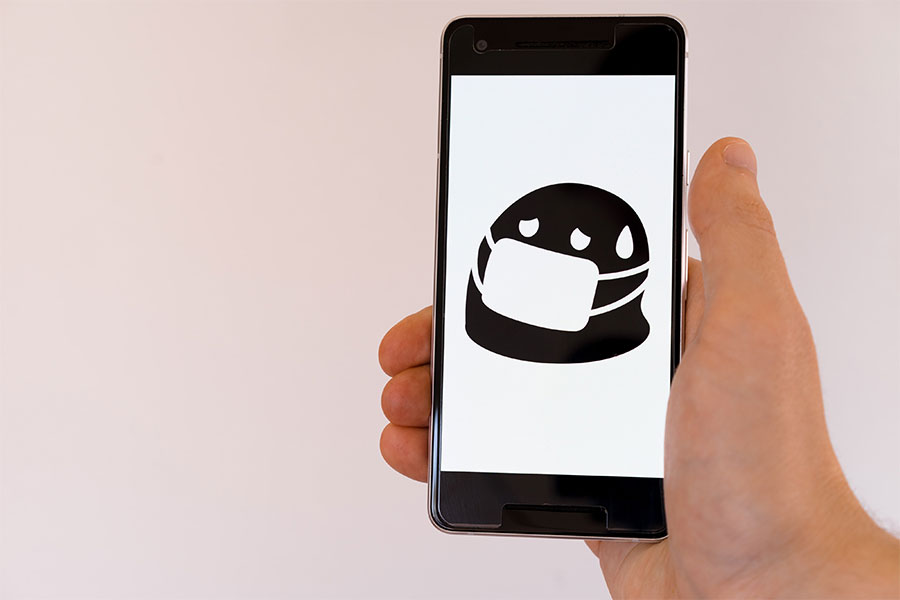Emoji con mascarilla en la pantalla de un móvil 